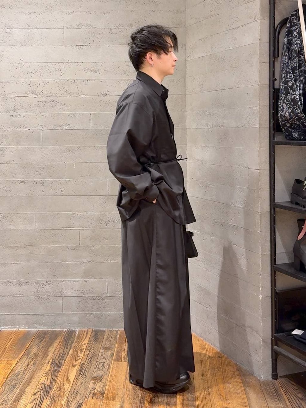 ブラック系のスニーカー、ブラック系のスラックス、ブラック系のショルダーバッグを着用したメンズの冬コーディネートの2枚目の写真