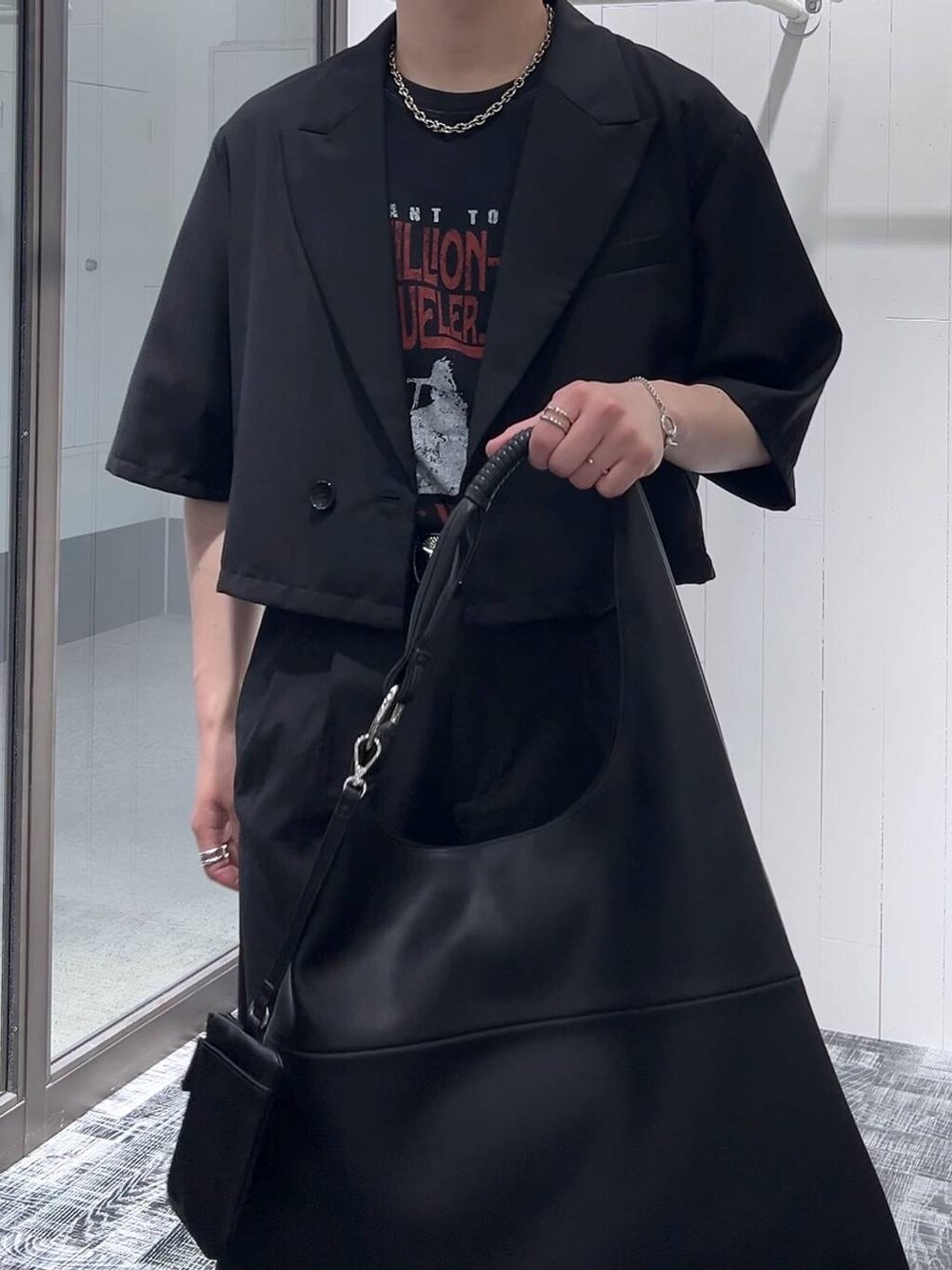ブラック系のドレスシューズ、ブラック系のトートバッグ、ブラック系のTシャツ/カットソーを着用したメンズの春コーディネートの5枚目の写真