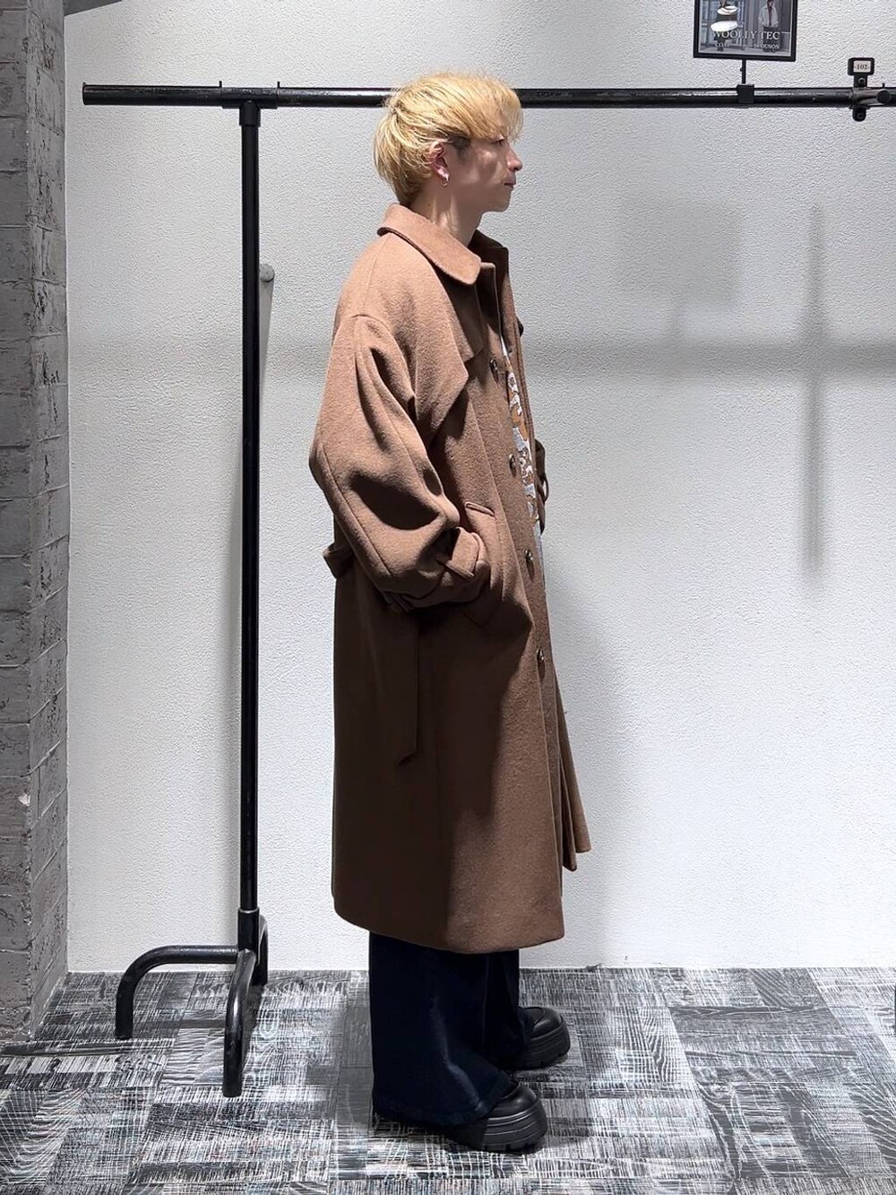 ブルー系のデニムパンツ、グレー系のニット/セーター、ブラウン系のステンカラーコートを着用したメンズの冬コーディネートの3枚目の写真