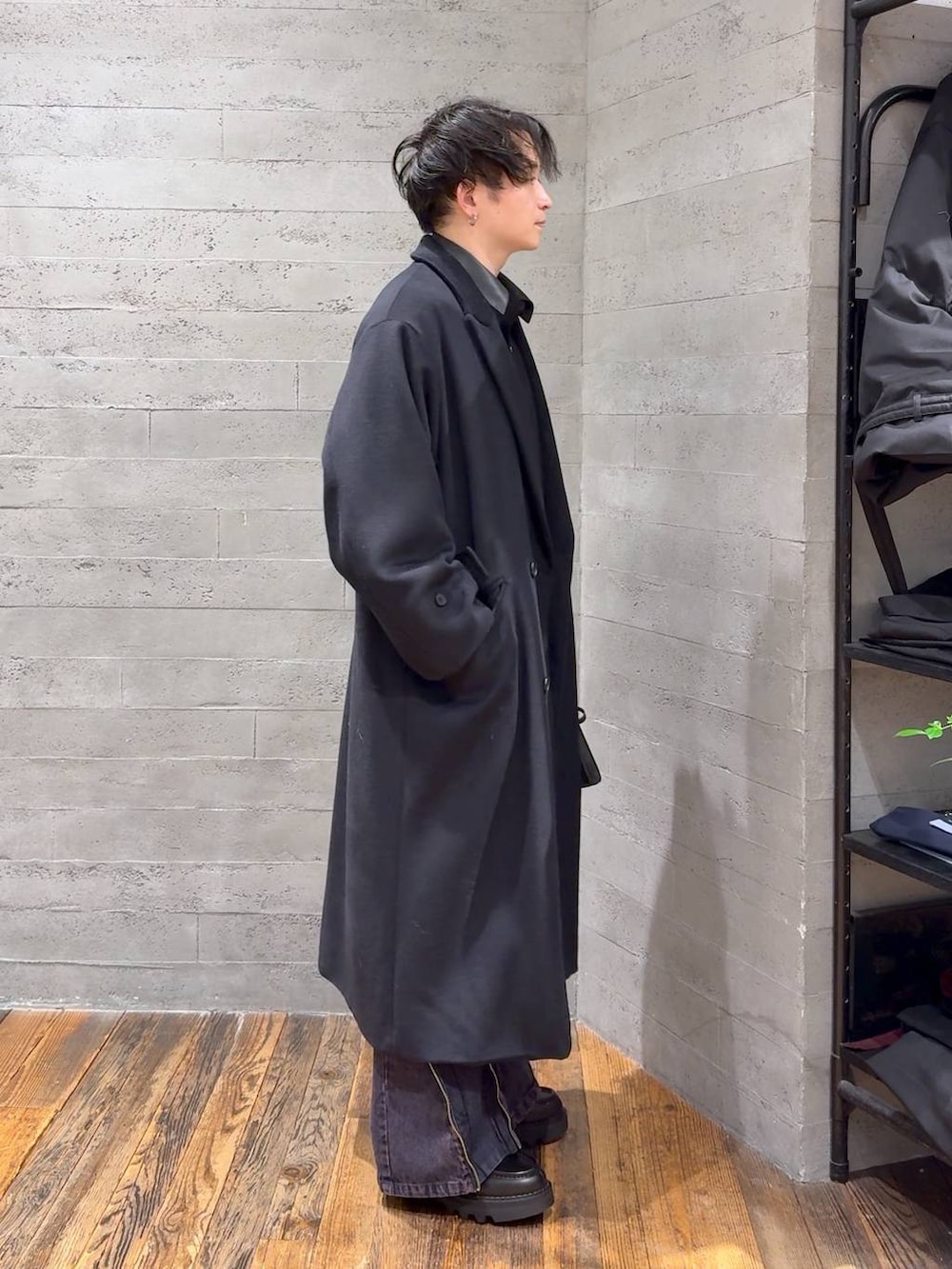 ブラック系のステンカラーコート、ブラック系のドレスシューズ、ブラック系のショルダーバッグを着用したメンズの冬コーディネートの2枚目の写真