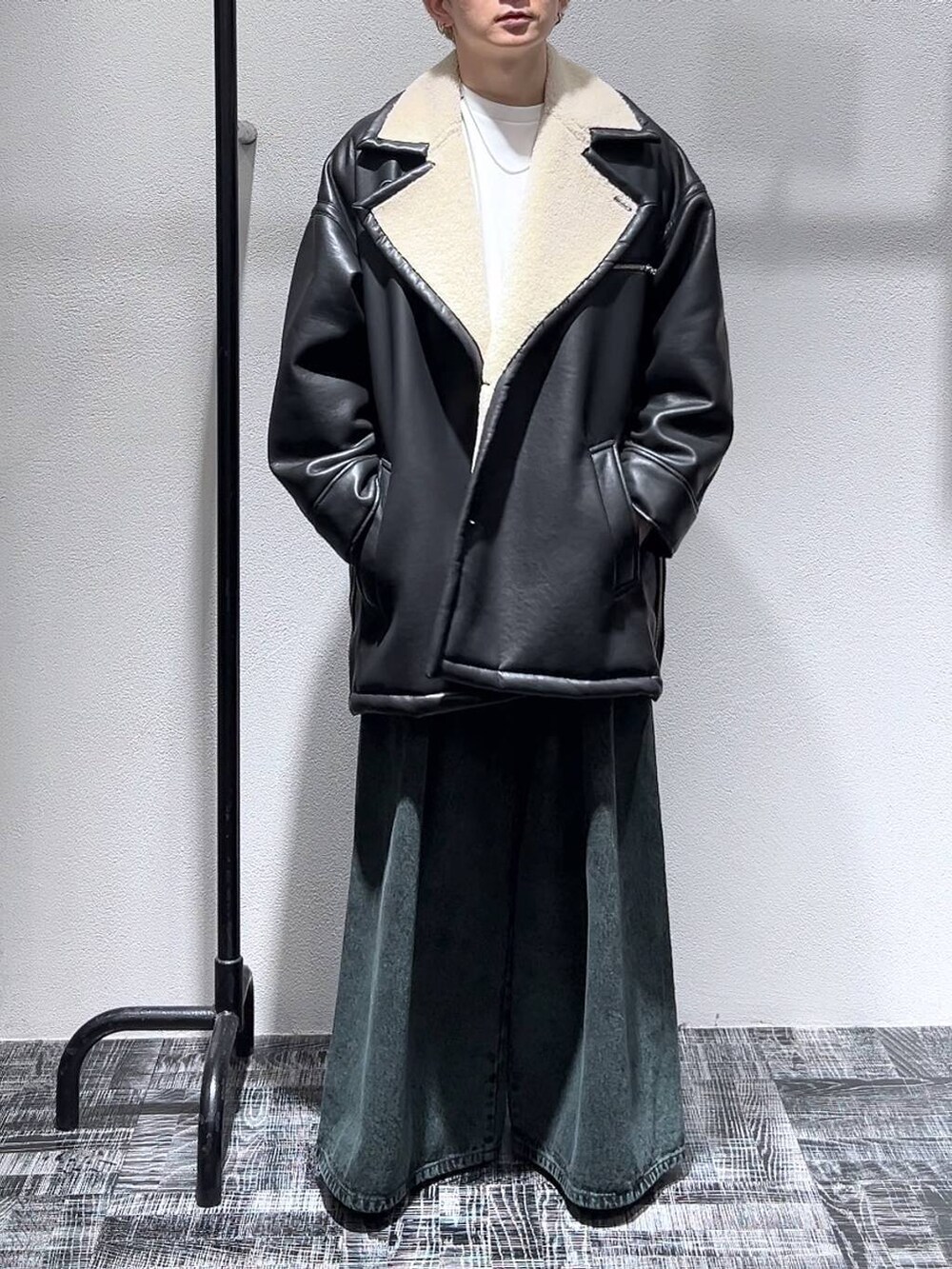 ブラック系のドレスシューズ、グリーン系のデニムパンツ、ブラック系のムートンコートを着用したメンズの冬コーディネートの2枚目の写真