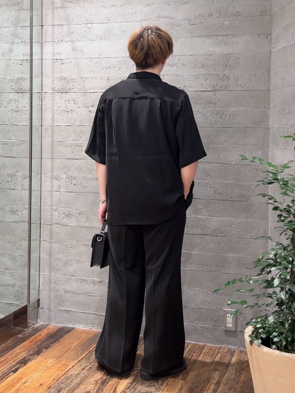 ブラック系のスラックス、ブラック系のシャツ/ブラウス、ブラック系のサンダルを着用したメンズの夏コーディネートの3枚目の写真