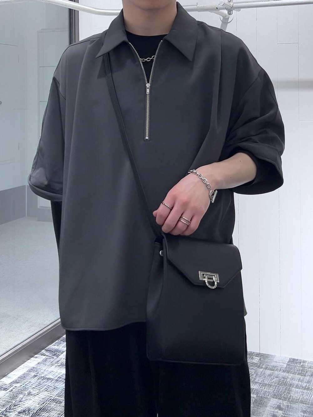 ブラック系のTシャツ/カットソー、ブラック系のショルダーバッグ、ブラック系のスラックスを着用したメンズの春コーディネートの5枚目の写真