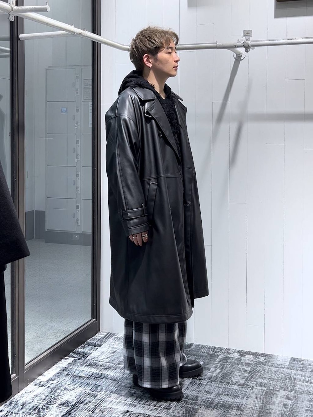 ブラック系のトレンチコート、ブラック系のその他パンツ、ブラック系のパーカーを着用したメンズの秋コーディネートの2枚目の写真