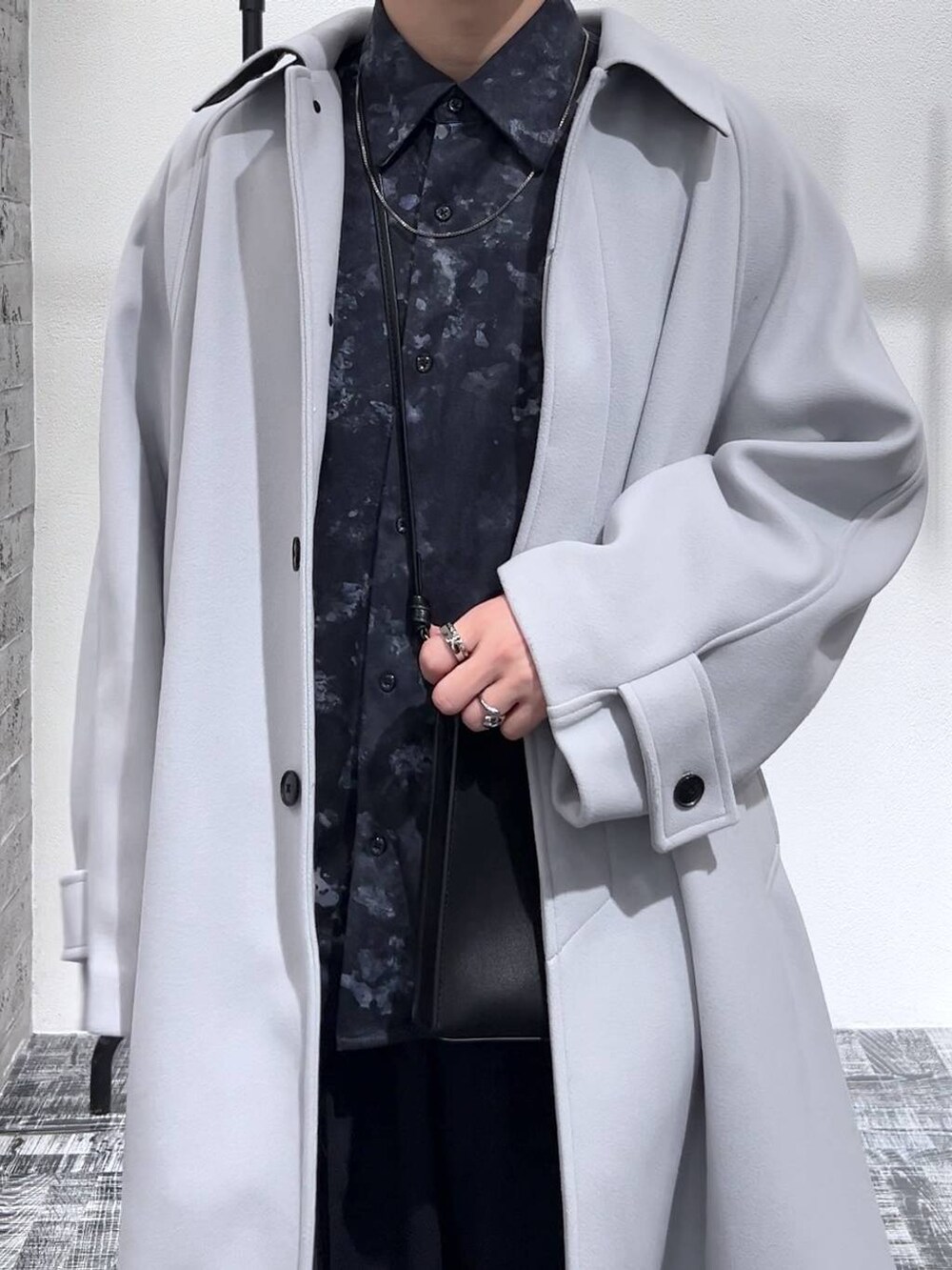 グレー系のステンカラーコート、ブラック系のショルダーバッグ、ブラック系のドレスシューズを着用したメンズの冬コーディネートの5枚目の写真