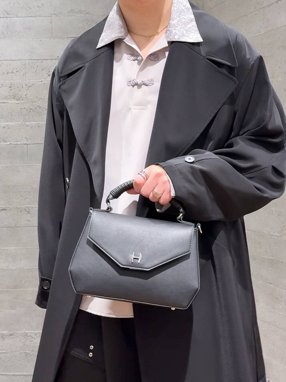 ブラック系のブーツ、ブラック系のトレンチコート、ブラック系のカーゴパンツを着用したメンズの春コーディネートの5枚目の写真