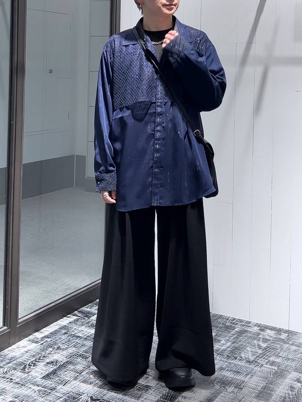 ブラック系のTシャツ/カットソー、ブラック系のショルダーバッグ、ブラック系のスラックスを着用したメンズの春コーディネートの2枚目の写真