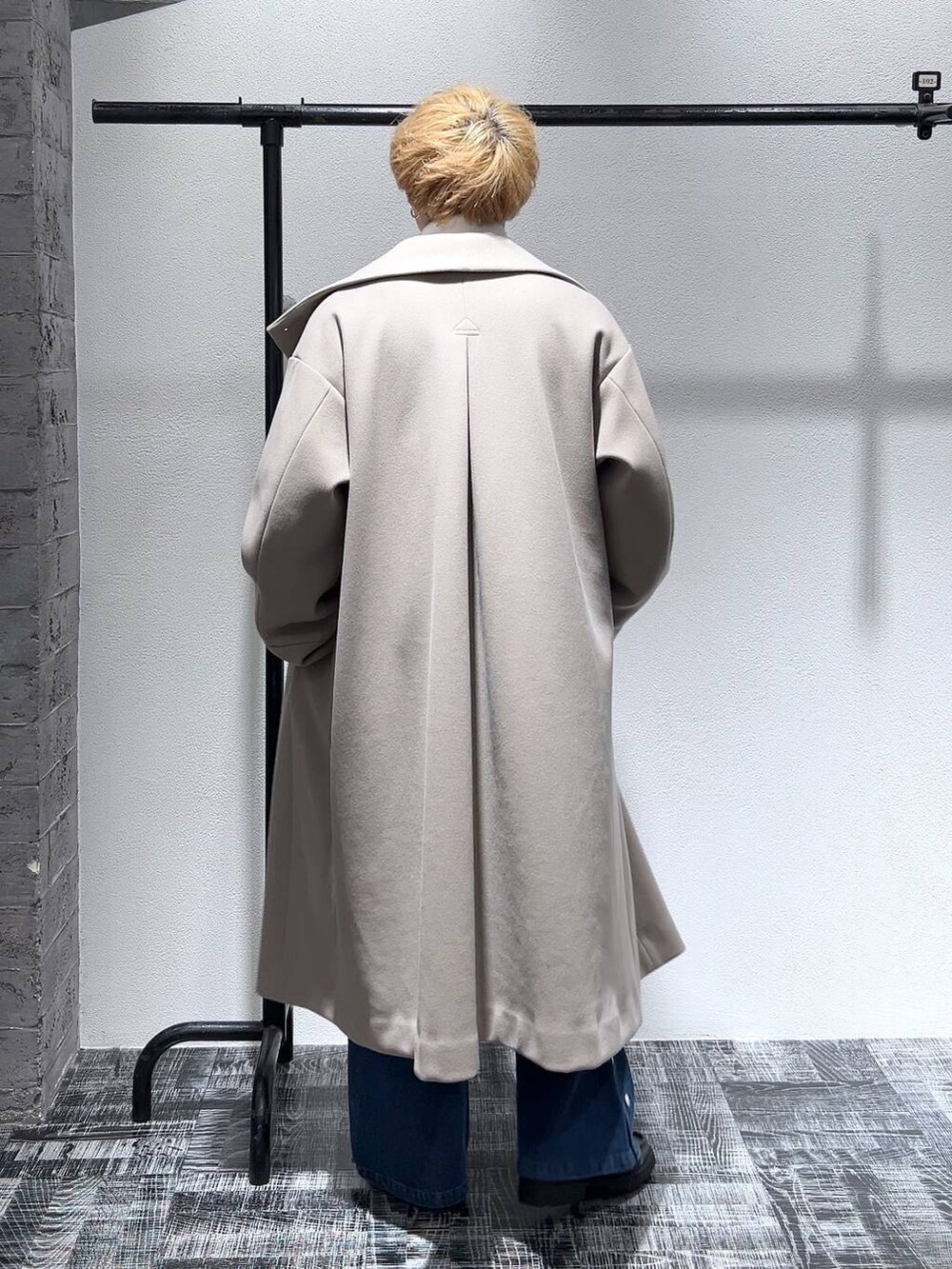 ブルー系のデニムパンツ、ブラック系のショルダーバッグ、ブラック系のドレスシューズを着用したメンズの冬コーディネートの4枚目の写真