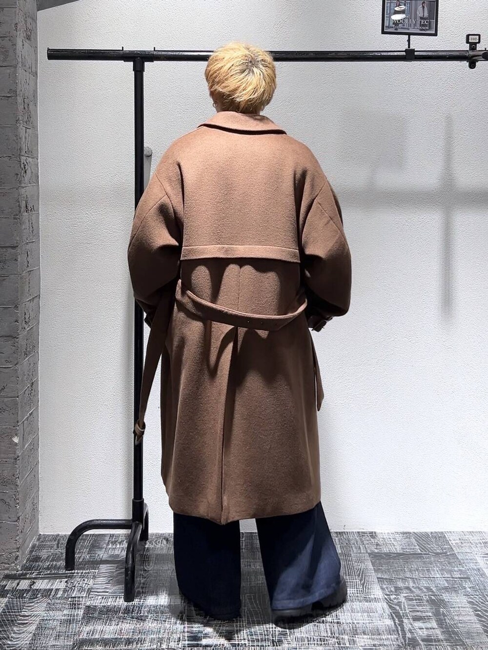 ブルー系のデニムパンツ、グレー系のニット/セーター、ブラウン系のステンカラーコートを着用したメンズの冬コーディネートの4枚目の写真