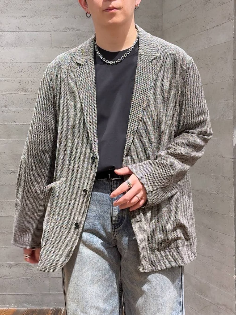 ブラック系のサンダル、グレー系のテーラードジャケット、ブルー系のデニムパンツを着用したメンズの春コーディネートの5枚目の写真