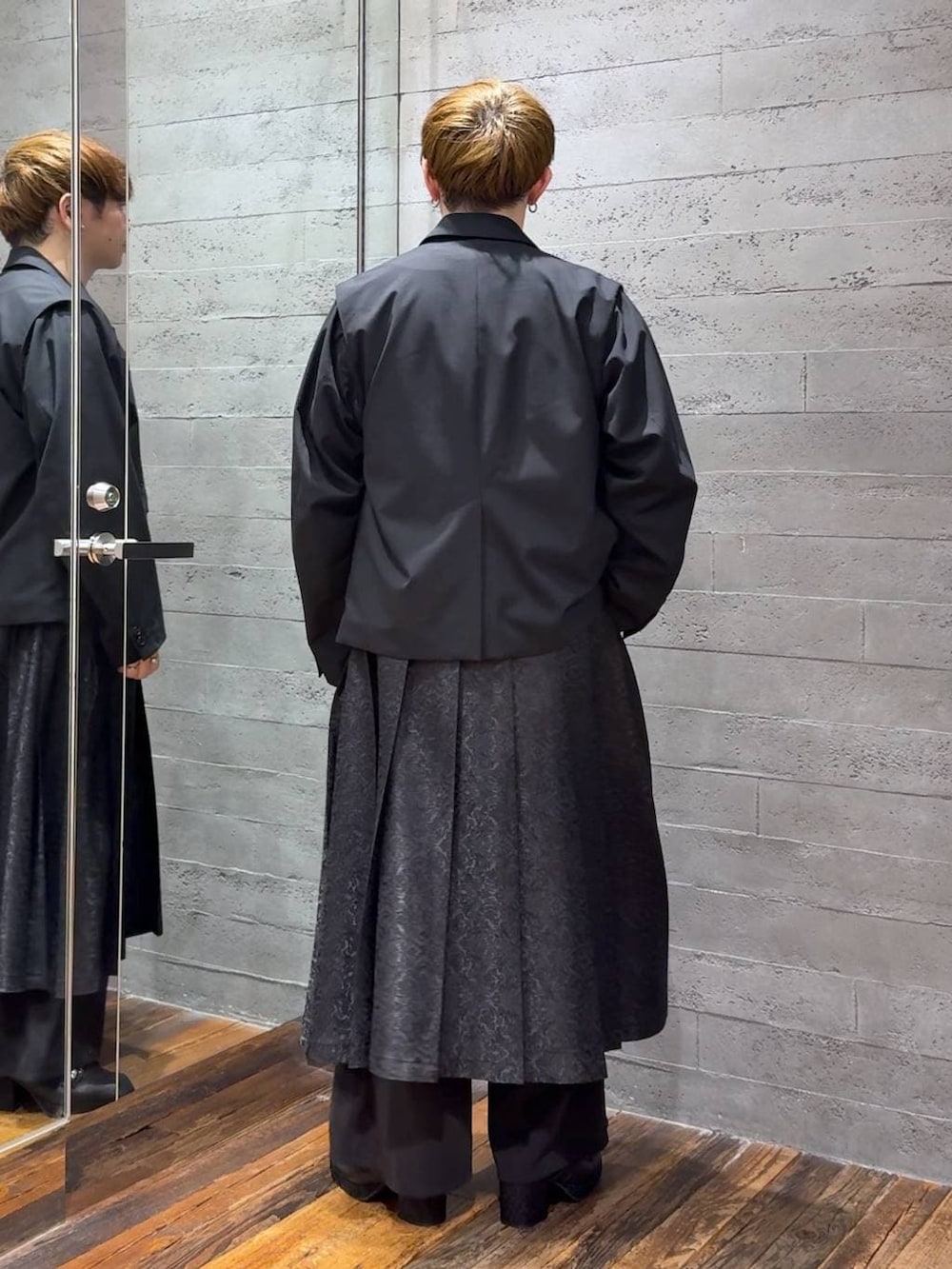 ブルー系のTシャツ/カットソー、ブラック系のサンダル、ブラック系のテーラードジャケットを着用したメンズの春コーディネートの3枚目の写真