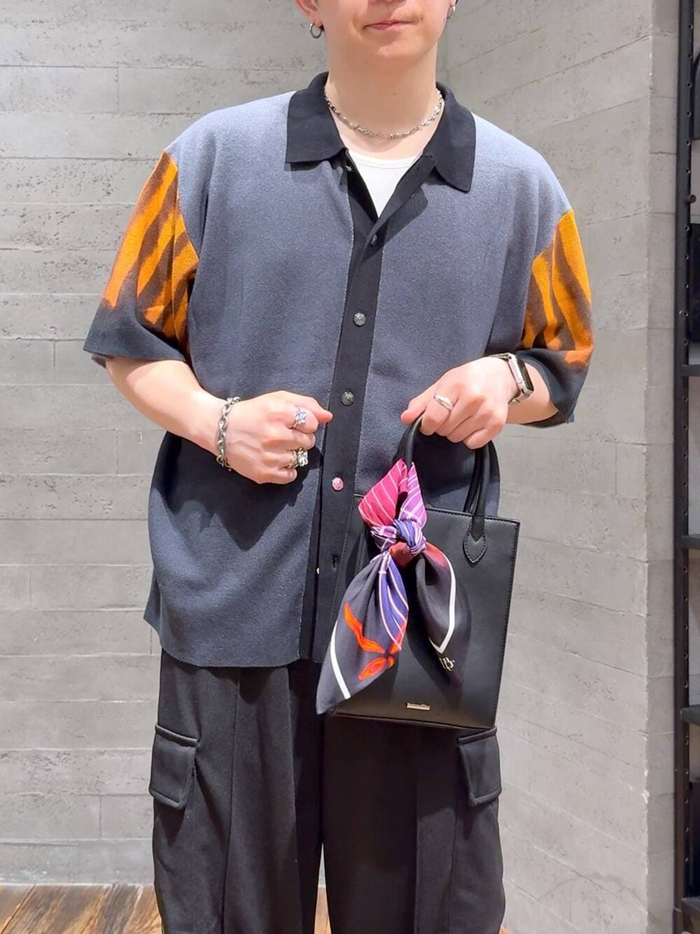 ブラック系のカーゴパンツ、ブラック系のニット/セーター、ブラック系のサンダルを着用したメンズの夏コーディネートの5枚目の写真