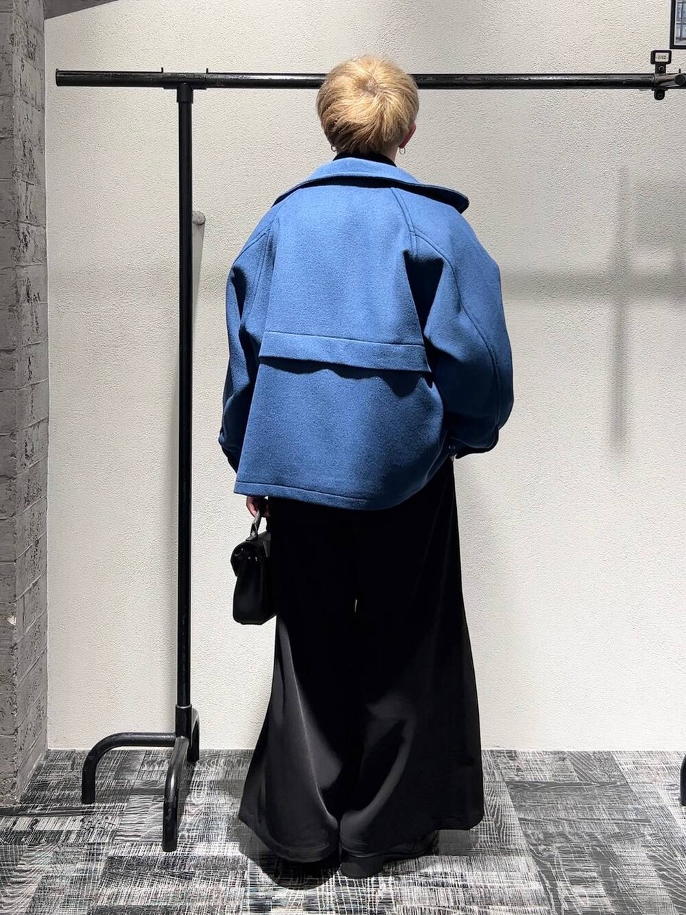 ブルー系のブルゾン、ブラック系のスラックス、ブラック系のショルダーバッグを着用したメンズの秋コーディネートの3枚目の写真