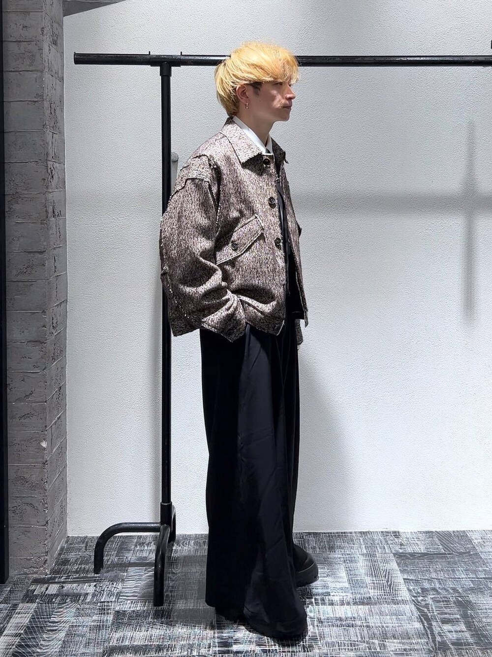 ブラック系のネクタイ、ブラウン系のブルゾン、ブラック系のスラックスを着用したメンズの冬コーディネートの3枚目の写真