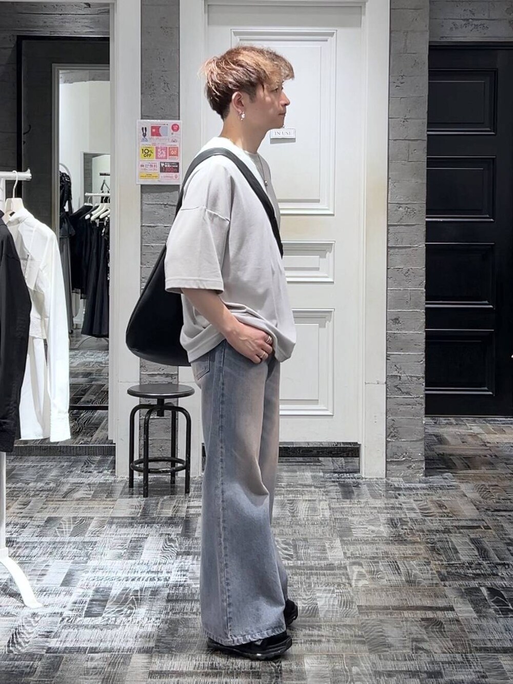 グレー系のTシャツ/カットソー、パープル系のデニムパンツ、ブラック系のサンダルを着用したメンズの夏コーディネートの3枚目の写真