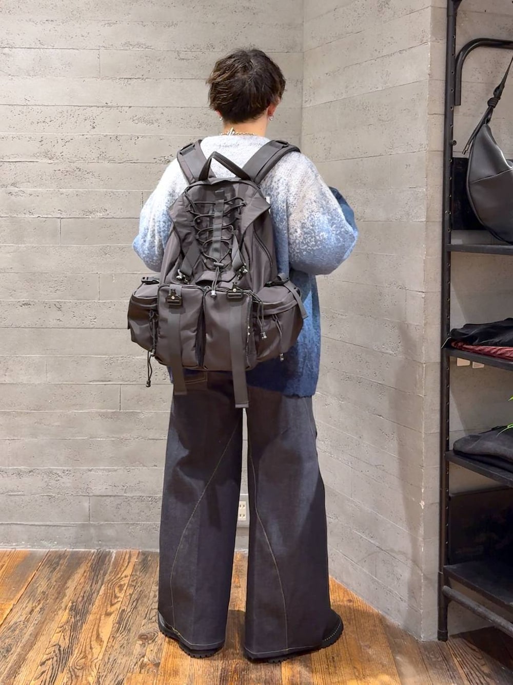 ブルー系のデニムパンツ、ブルー系のカーディガン/ボレロ、ブラック系のバックパック/リュックを着用したメンズの秋コーディネートの3枚目の写真