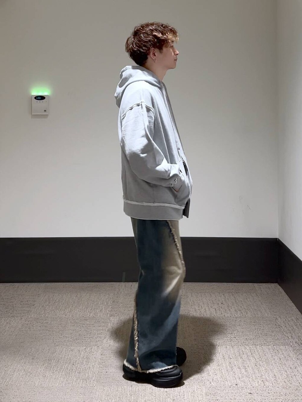 ブラック系のスニーカー、ブルー系のデニムパンツ、グレー系のパーカーを着用したメンズの秋コーディネートの4枚目の写真