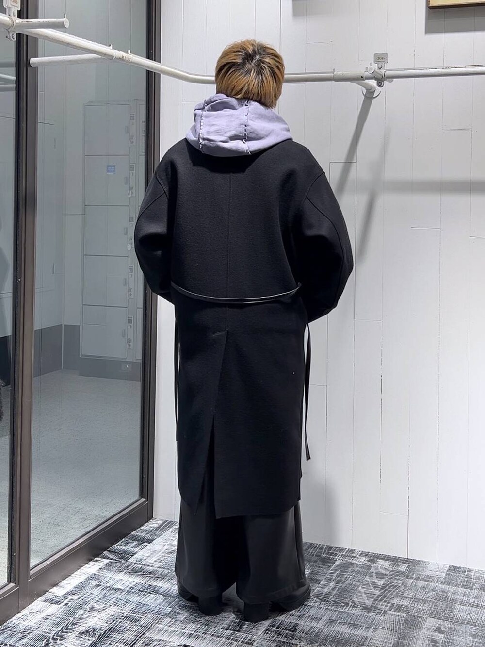 ブラック系のトレンチコート、ブラック系のその他パンツ、ブラック系のTシャツ/カットソーを着用したメンズの冬コーディネートの3枚目の写真
