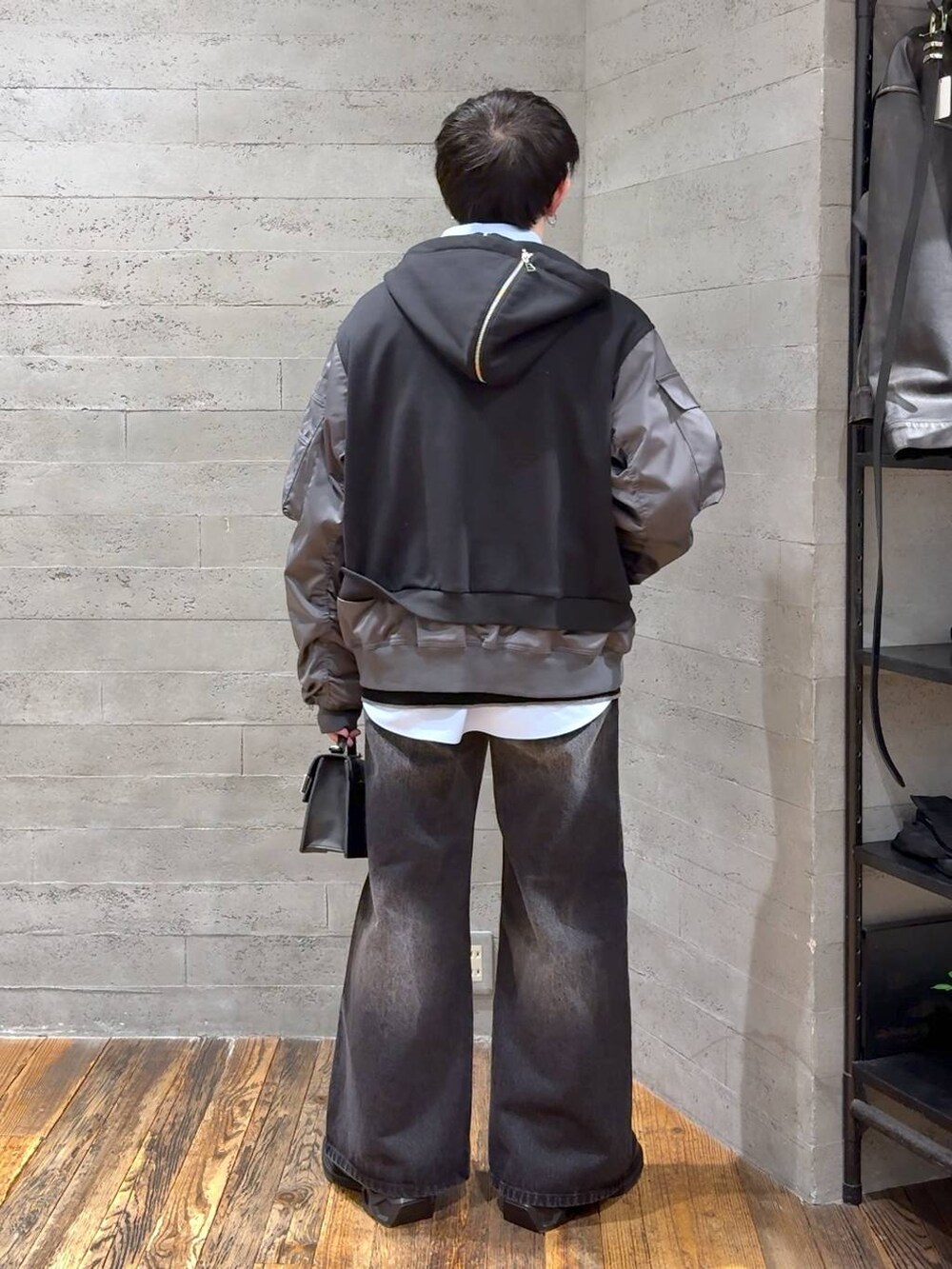 ブラック系のデニムパンツ、ブラック系のポロシャツ、ブラック系のローファーを着用したメンズの冬コーディネートの3枚目の写真