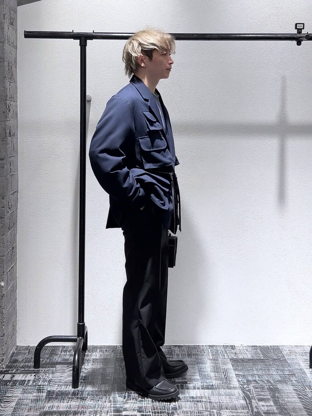 ブルー系のテーラードジャケット、ブラック系のスラックス、ブルー系のスウェットを着用したメンズの冬コーディネートの3枚目の写真