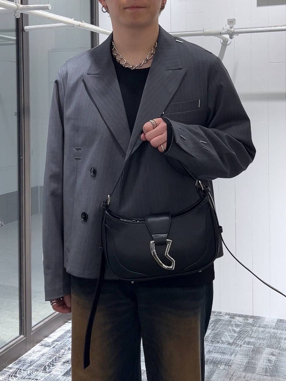 ブルー系のデニムパンツ、ブラック系のTシャツ/カットソー、ブラック系のドレスシューズを着用したメンズの冬コーディネートの5枚目の写真