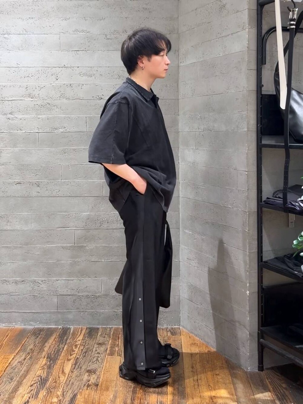 ブラック系のトートバッグ、ブラック系のサンダル、ブラック系のTシャツ/カットソーを着用したメンズの春コーディネートの2枚目の写真