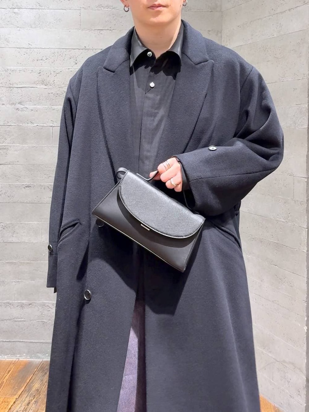 ブラック系のステンカラーコート、ブラック系のドレスシューズ、ブラック系のショルダーバッグを着用したメンズの冬コーディネートの5枚目の写真