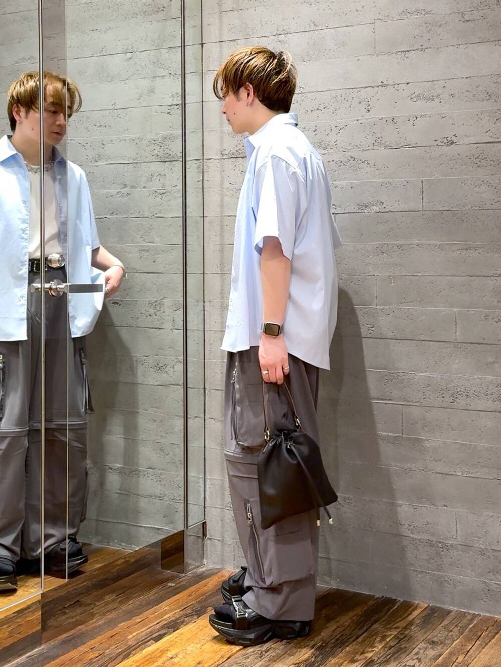 ブラック系のサンダル、ホワイト系のTシャツ/カットソー、グレー系のカーゴパンツを着用したメンズの春コーディネートの4枚目の写真
