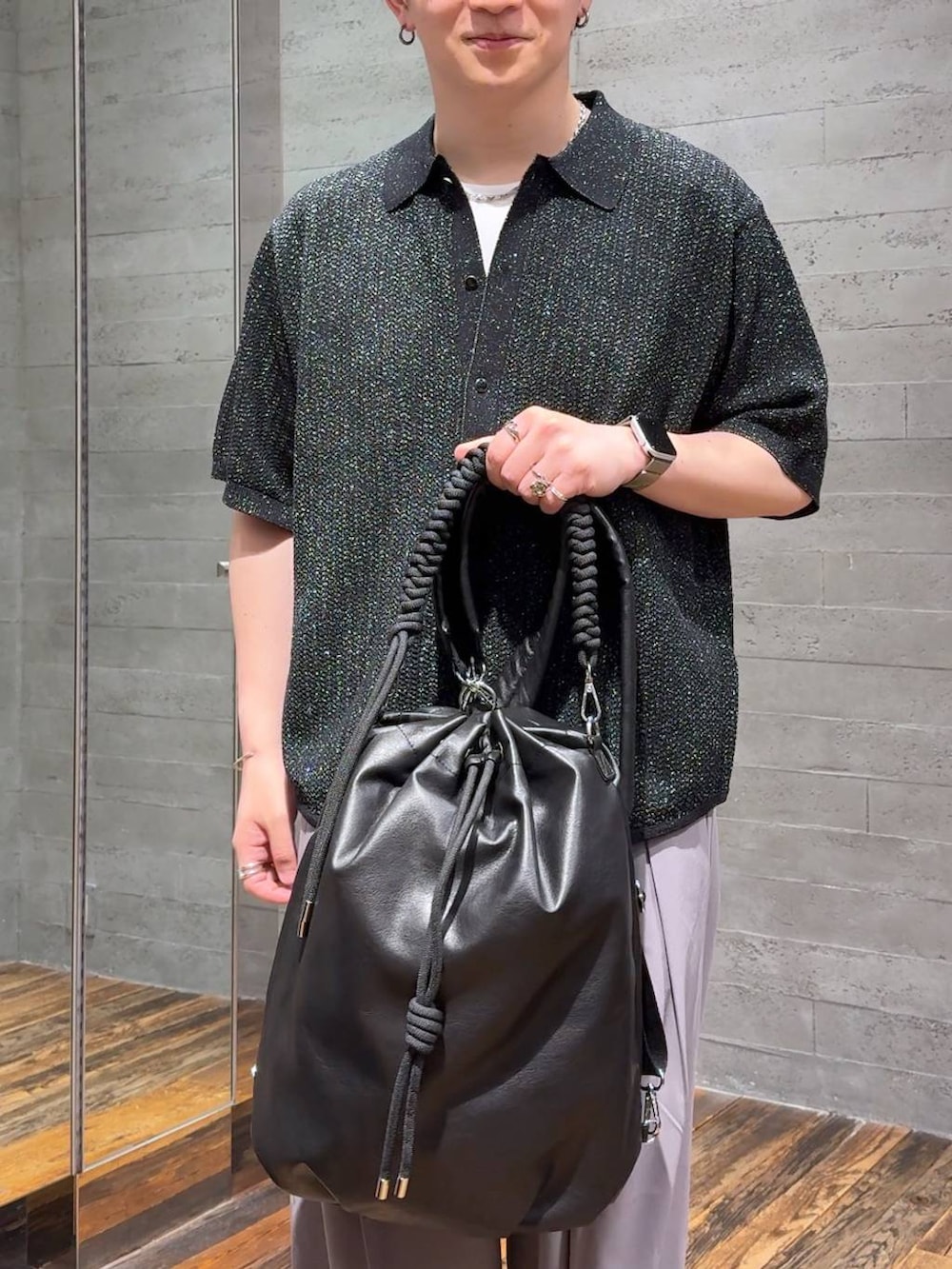 ホワイト系のTシャツ/カットソー、ブラック系のサンダル、ブラウン系のスラックスを着用したメンズの夏コーディネートの5枚目の写真