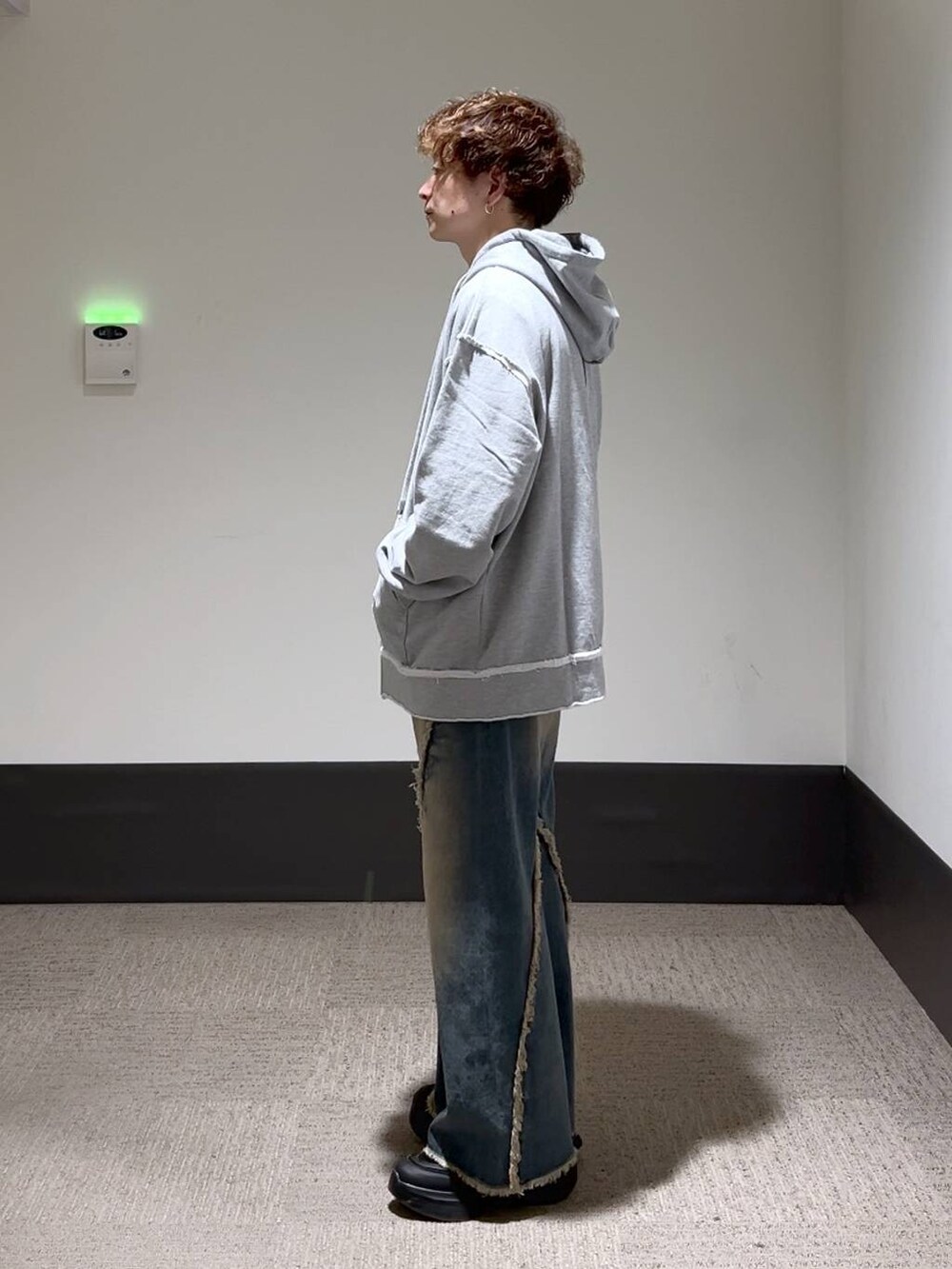 ブラック系のスニーカー、ブルー系のデニムパンツ、グレー系のパーカーを着用したメンズの秋コーディネートの2枚目の写真