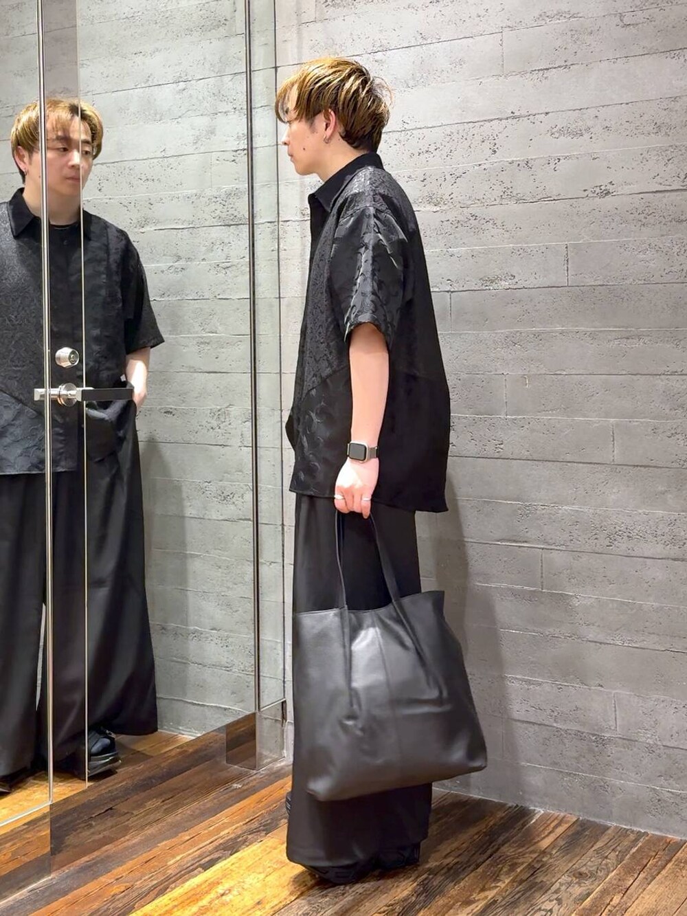 ブラック系のサンダル、ブラック系のTシャツ/カットソー、ブラック系のトートバッグを着用したメンズの春コーディネートの4枚目の写真