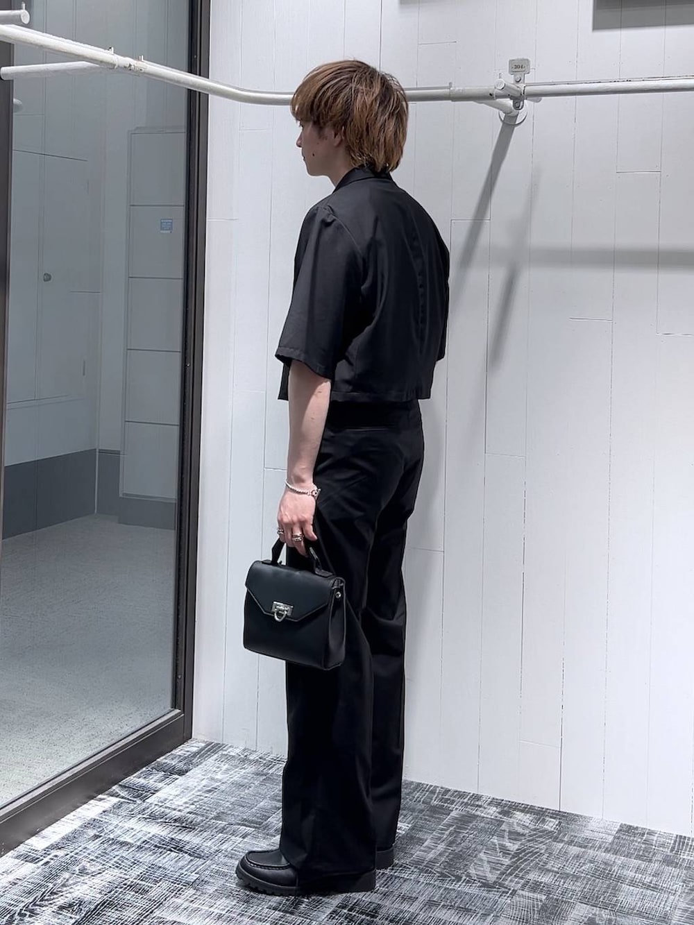 ホワイト系のTシャツ/カットソー、ブラック系のドレスシューズ、ブラック系のショルダーバッグを着用したメンズの春コーディネートの2枚目の写真