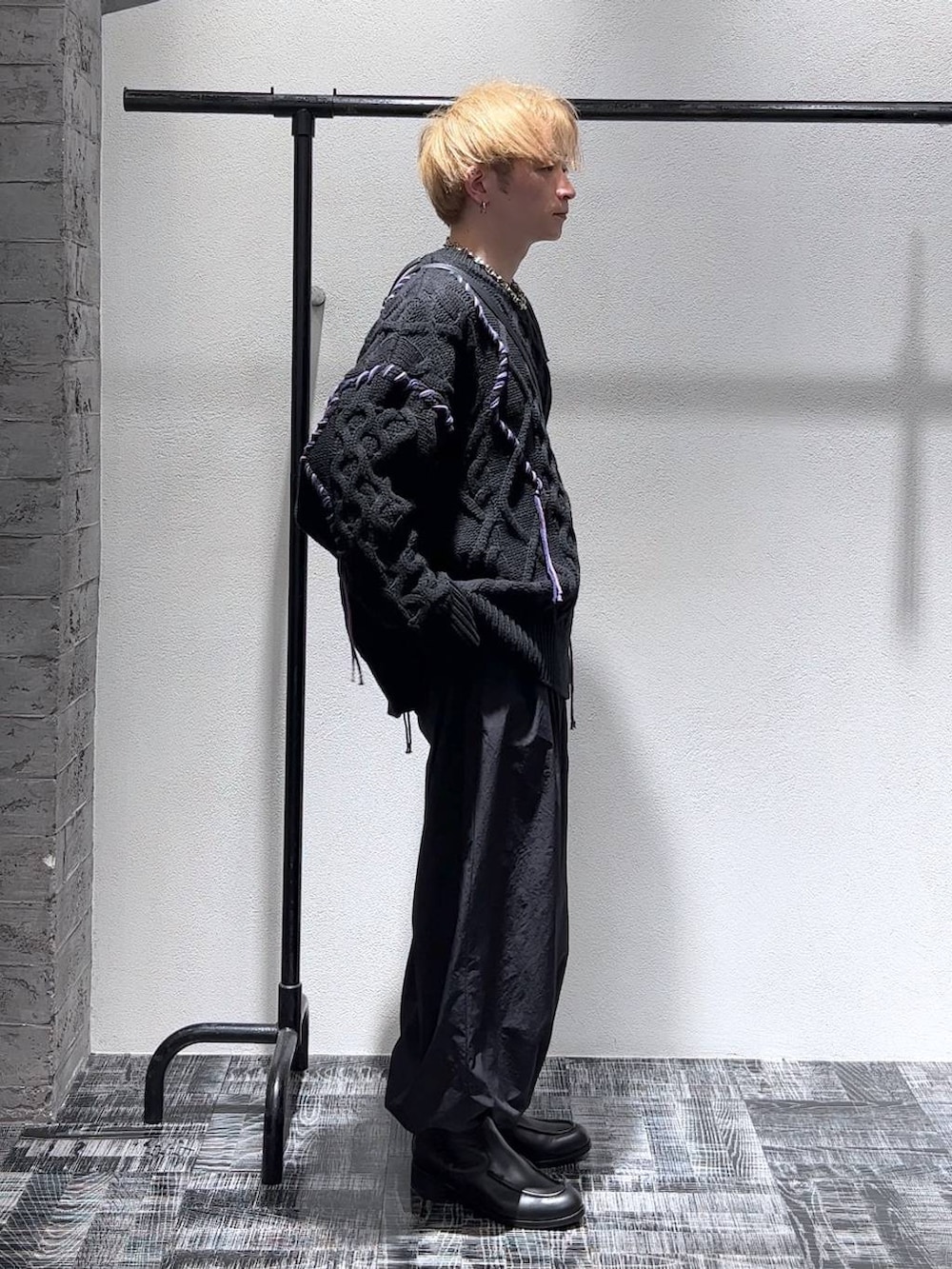 ブラック系のショルダーバッグ、ブラック系のブーツ、ブラック系のニット/セーターを着用したメンズの秋コーディネートの3枚目の写真