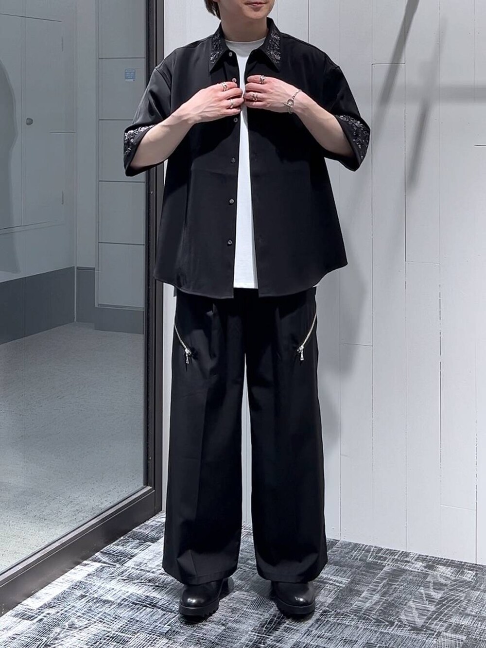 ブラック系のドレスシューズ、ブラック系のシャツ/ブラウス、ホワイト系のTシャツ/カットソーを着用したメンズの春コーディネートの2枚目の写真