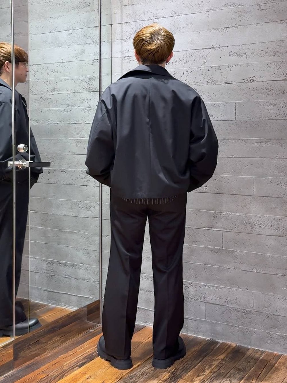 ブラック系のスラックス、ブラック系のブルゾン、ブラック系のシャツ/ブラウスを着用したメンズの春コーディネートの3枚目の写真