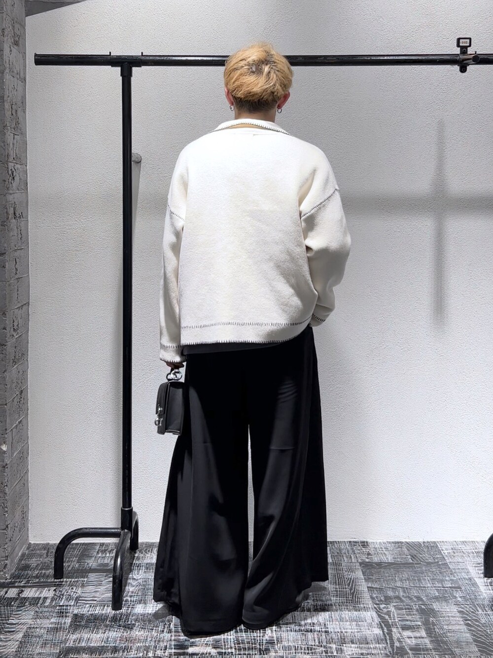 グレー系のスウェット、ホワイト系のニット/セーター、ブラック系のパンツを着用したメンズの秋コーディネートの3枚目の写真