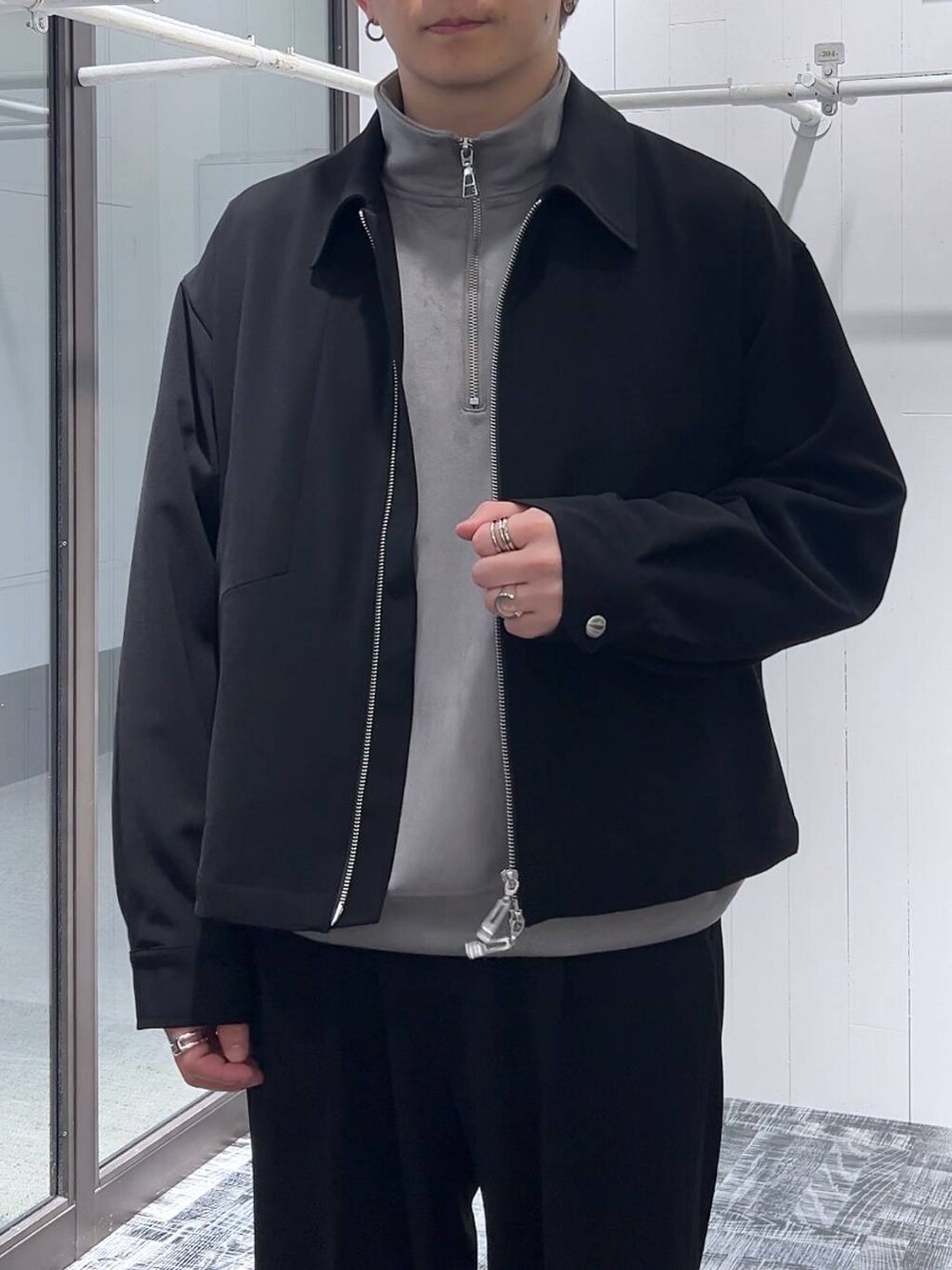 グレー系のスウェット、ブラック系のスラックス、ブラック系のドレスシューズを着用したメンズの冬コーディネートの5枚目の写真