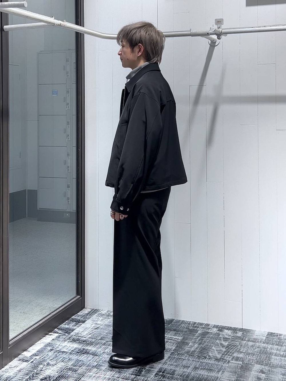 グレー系のスウェット、ブラック系のスラックス、ブラック系のドレスシューズを着用したメンズの冬コーディネートの4枚目の写真