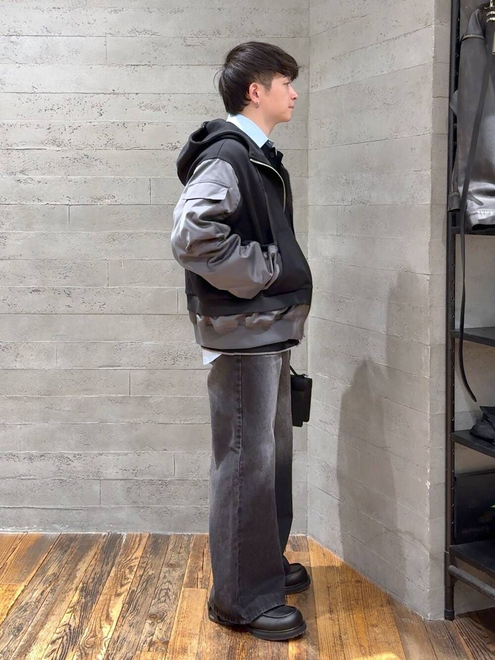 ブラック系のデニムパンツ、ブラック系のポロシャツ、ブラック系のローファーを着用したメンズの冬コーディネートの2枚目の写真