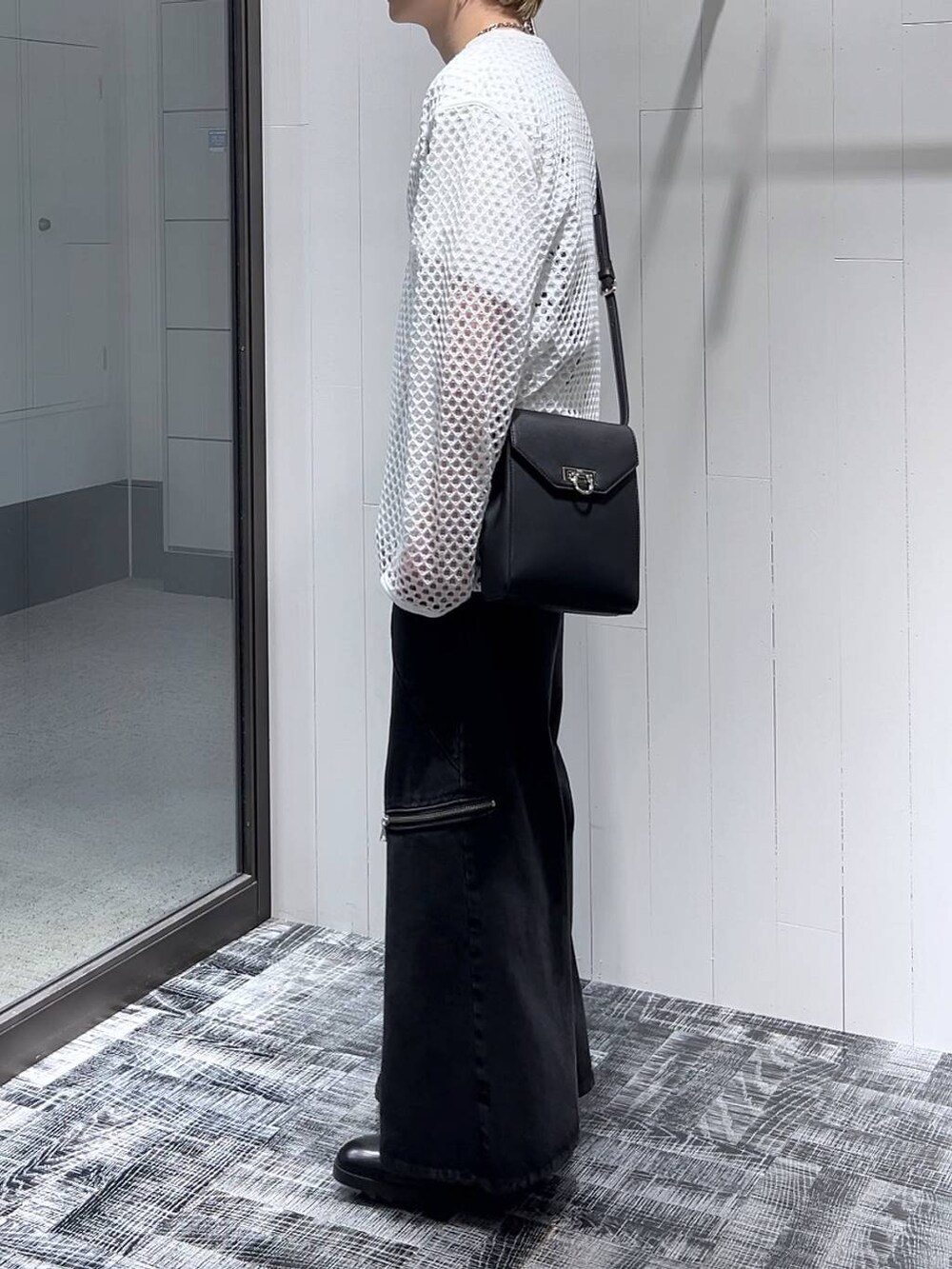 ブラック系のショルダーバッグ、ブラック系のデニムパンツ、ブラック系のドレスシューズを着用したメンズの春コーディネートの4枚目の写真