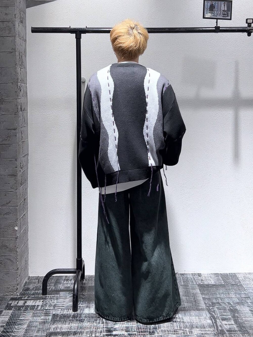 ブラック系のドレスシューズ、ブラック系のカーディガン/ボレロ、グリーン系のデニムパンツを着用したメンズの冬コーディネートの4枚目の写真