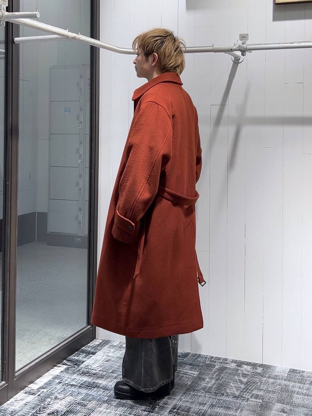 オレンジ系のステンカラーコート、グレー系のカーゴパンツ、ピンク系のカーディガン/ボレロを着用したメンズの冬コーディネートの4枚目の写真