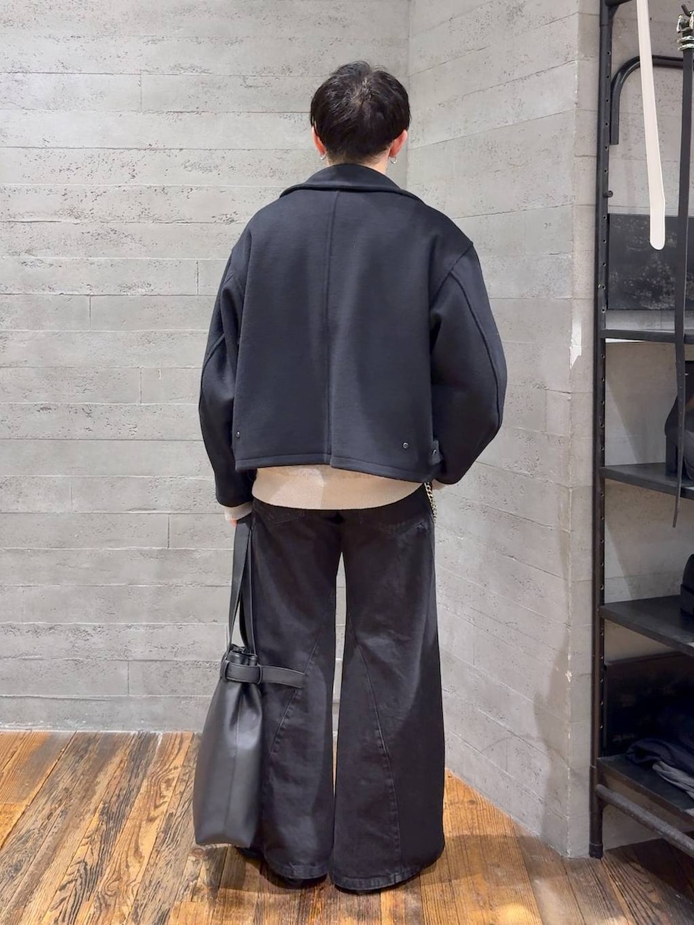 ブラック系のデニムパンツ、ブラック系のブルゾン、ブラック系のトートバッグを着用したメンズの秋コーディネートの3枚目の写真