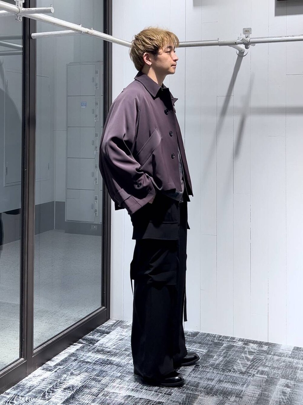 レッド系のブルゾン、ブラック系のカーゴパンツ、ブラック系のドレスシューズを着用したメンズの秋コーディネートの2枚目の写真