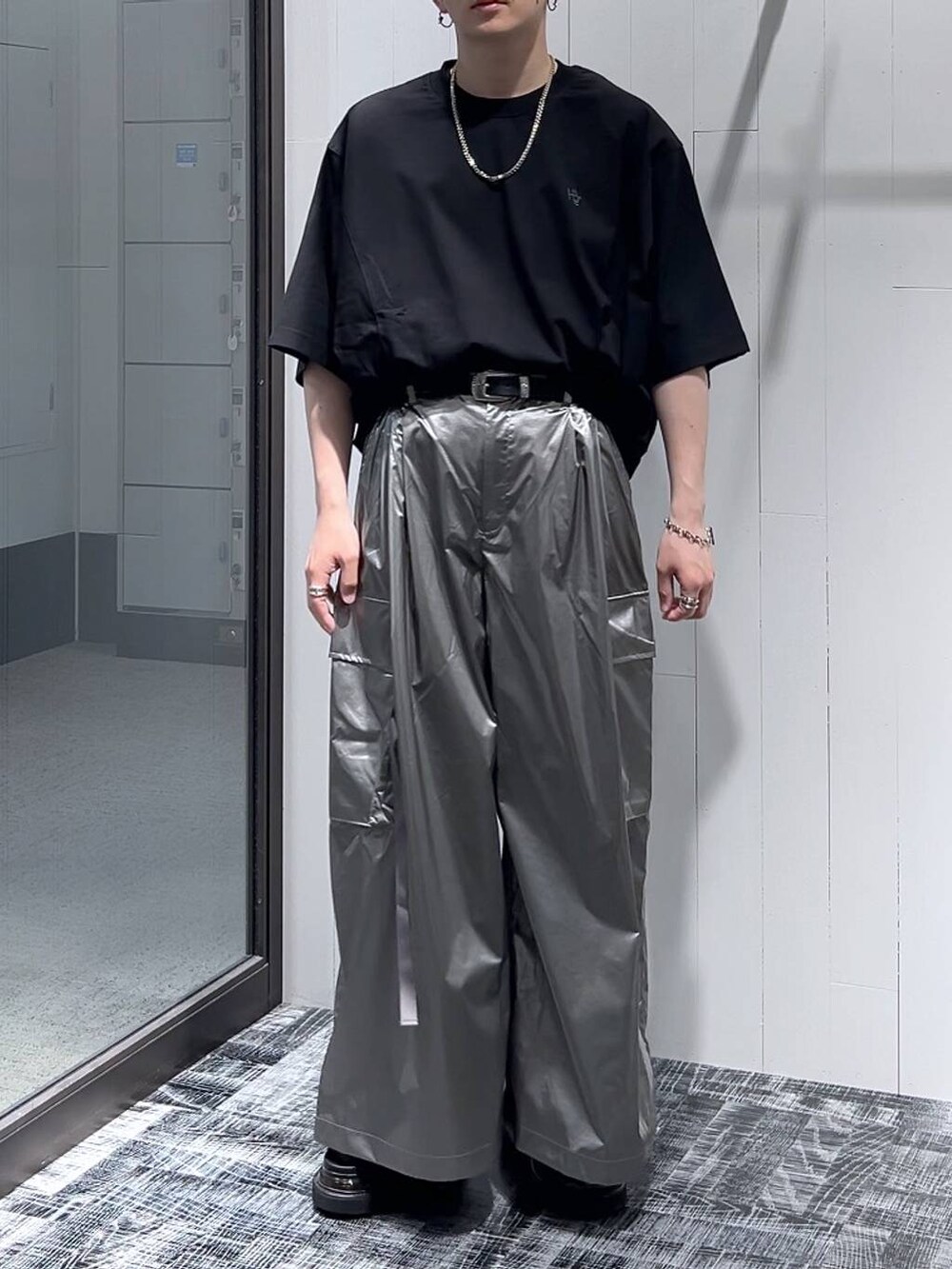 ブラック系のTシャツ/カットソー、ブラック系のサンダル、シルバー系のカーゴパンツを着用したメンズの夏コーディネートの2枚目の写真