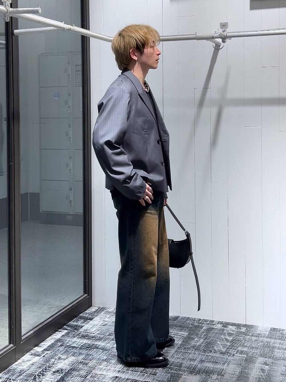 ブルー系のデニムパンツ、ブラック系のTシャツ/カットソー、ブラック系のドレスシューズを着用したメンズの冬コーディネートの2枚目の写真