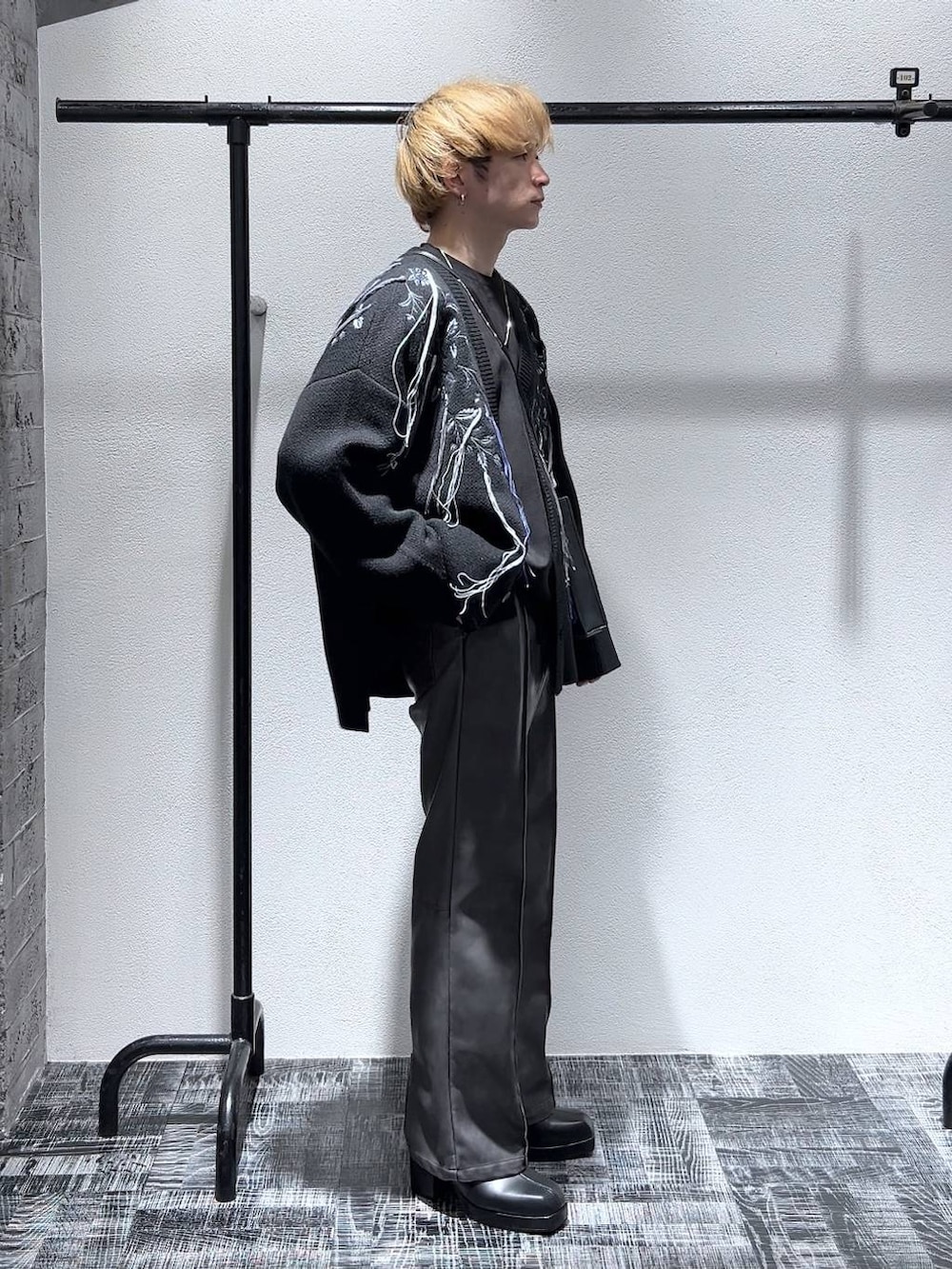 ブラック系のカーディガン/ボレロ、ブラック系のブーツ、ブラック系のショルダーバッグを着用したメンズの冬コーディネートの2枚目の写真