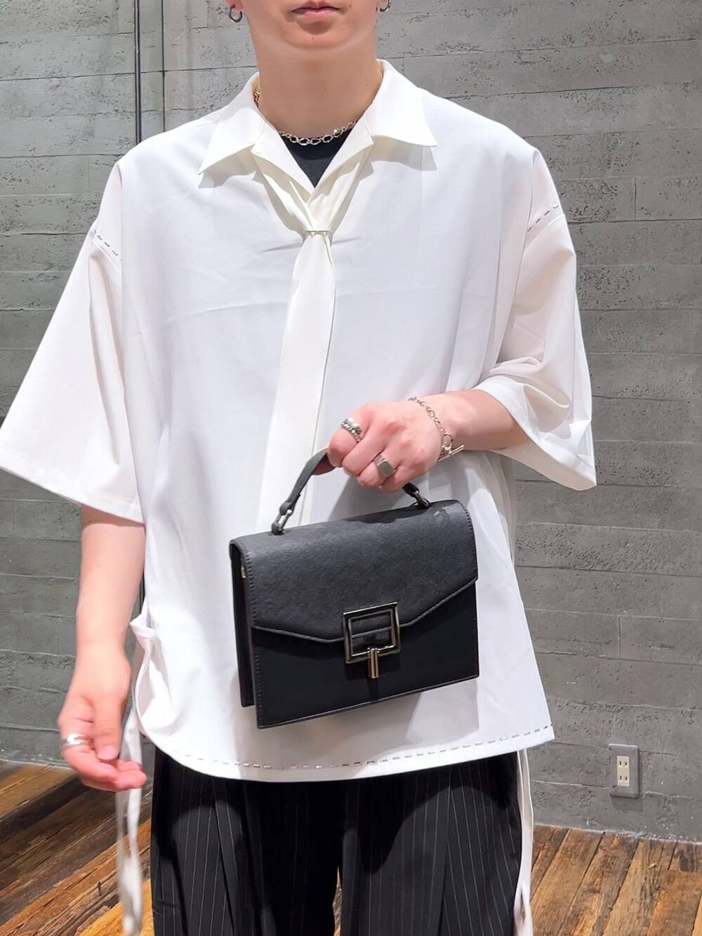 ブラック系のサンダル、ホワイト系のシャツ/ブラウス、ブラック系のショルダーバッグを着用したメンズの夏コーディネートの5枚目の写真