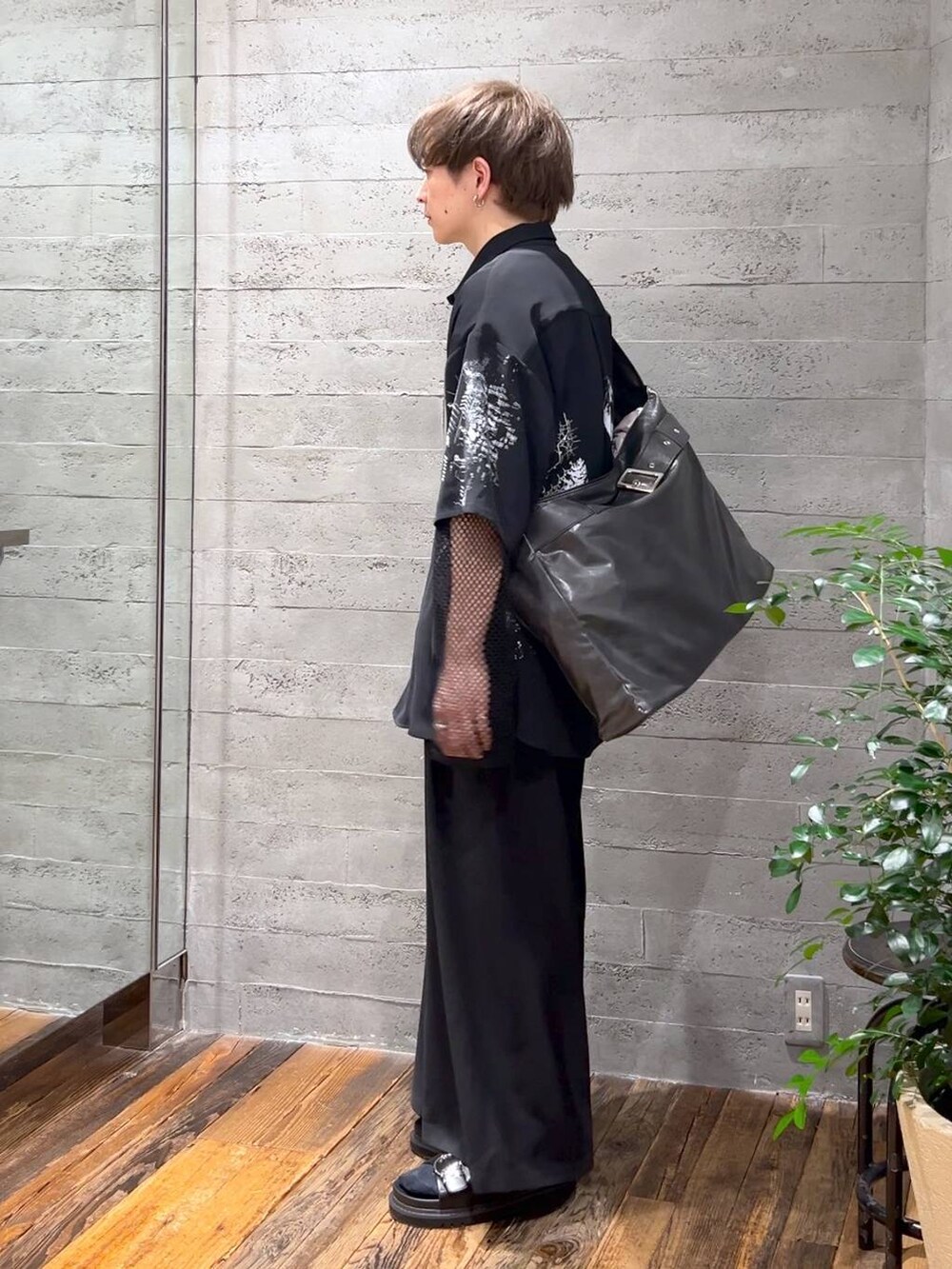 ブラック系のサンダル、グレー系のショルダーバッグ、ブラック系のスラックスを着用したメンズの春コーディネートの2枚目の写真