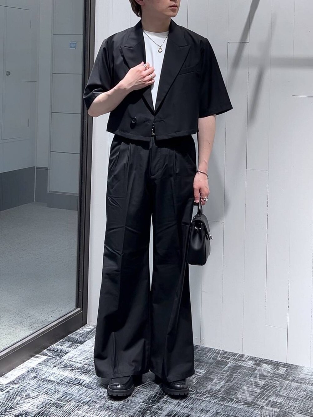 ホワイト系のTシャツ/カットソー、ブラック系のドレスシューズ、ブラック系のショルダーバッグを着用したメンズの春コーディネートの2枚目の写真